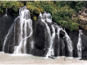 Hraunfossar waterval waar het water tussen de lava in de rivier stroomt